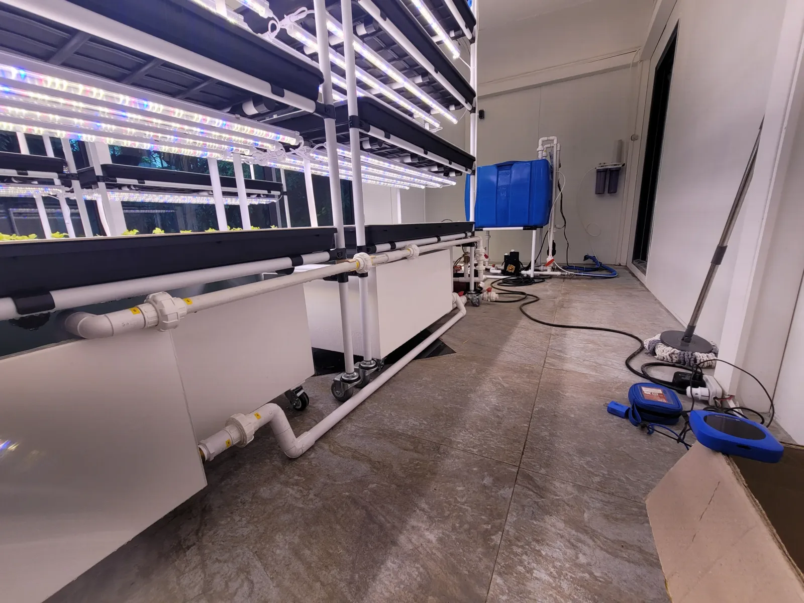 실내수직농장 재배랙 옆으로 양액탱크와 배관이 이어진 모습
